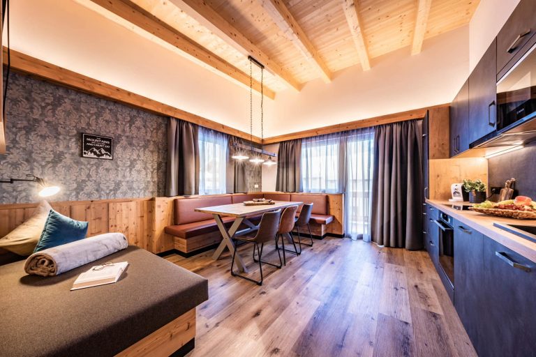 Modern eingerichtetes Apartment mit Holzelementen, Sitzbank und großem Esstisch