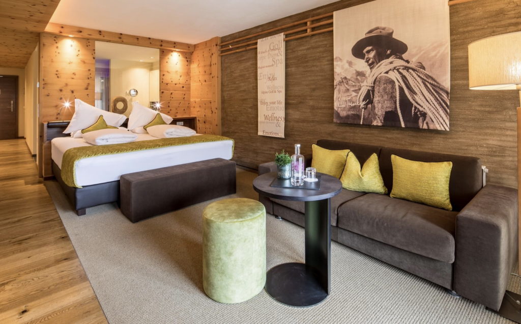 Hotelzimmer mit Doppelbett, Sitzbereich und warmem Beleuchtungskonzept